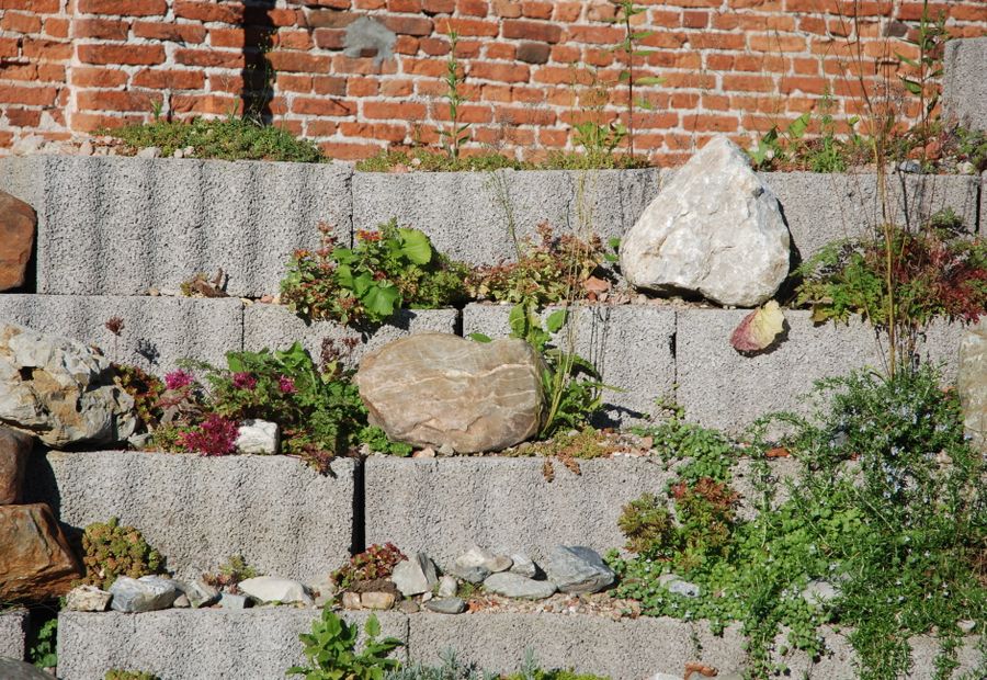 Segmental block retaining wall with battered courses and a stone drainage column behind